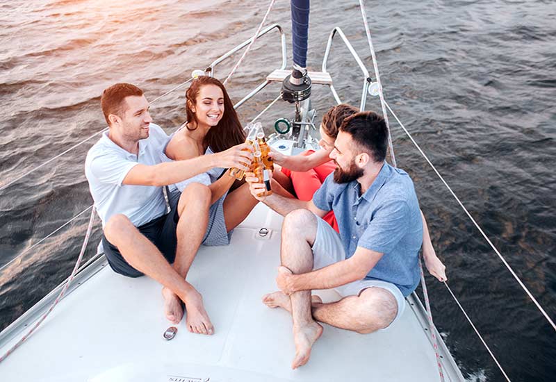 Four people being social on a yacht with drinks